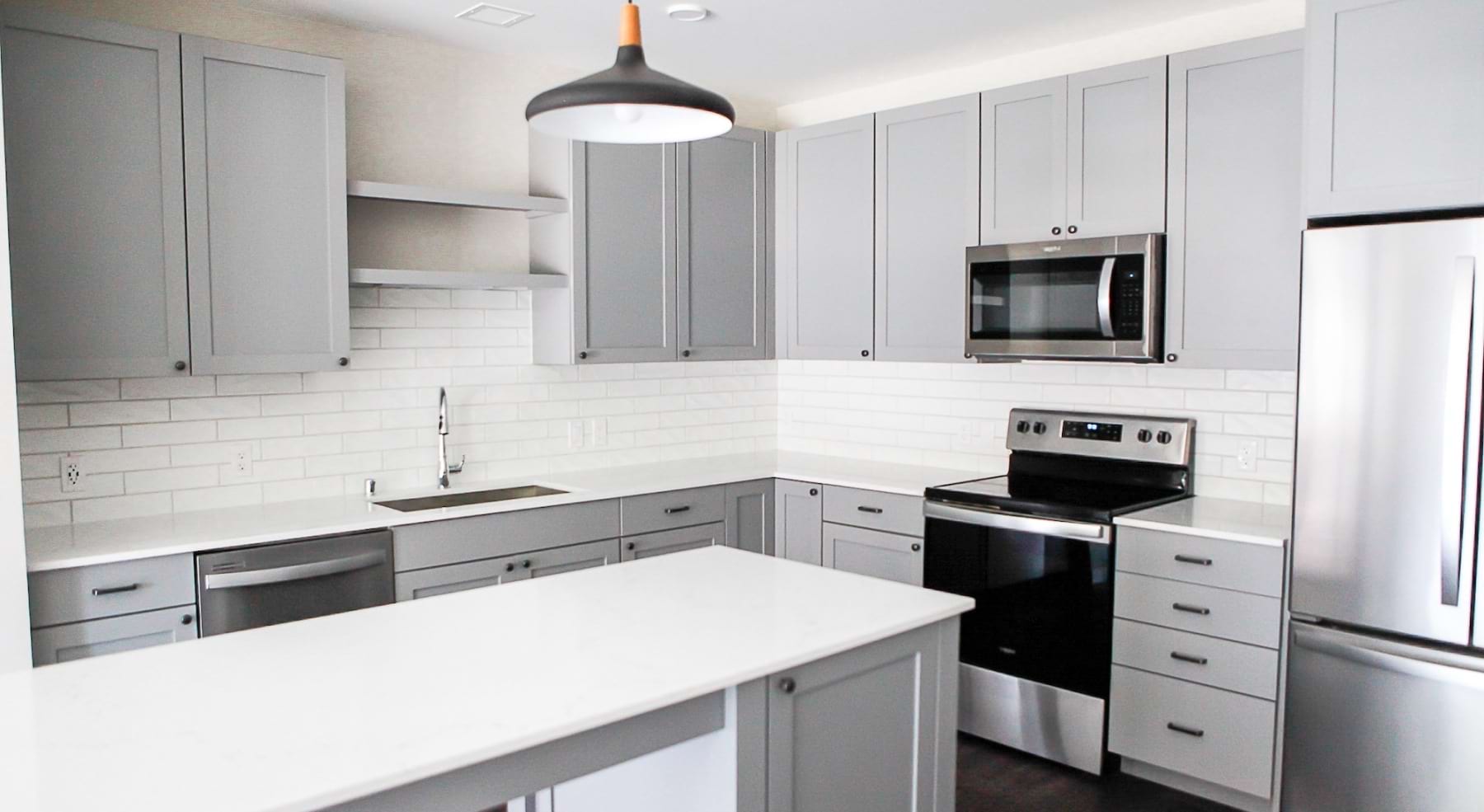 kitchen with grey cabinets and white tiled backsplash