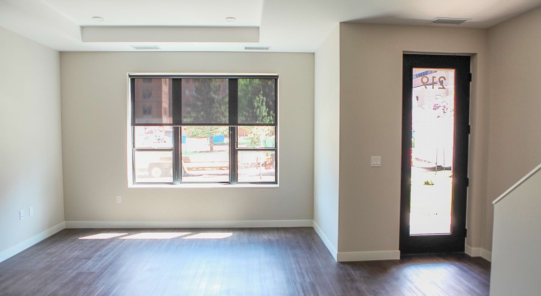 room with white wall wood floors and a glass door
